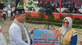Bupati Aceh Utara H. Ismail A. Jalil (Ayahwa) menyerahkan secara simbolis donasi siswa TK, SD, dan SMP Aceh Utara kepada Koordinator MER-C Aceh Ira Hadiati untuk anak-anak di Gaza, Palestina. Penyerahan donasi itu pada acara Maulid Akbar Nabi Besar Muhammad SAW 1447 H, yang digelar Pemkab Aceh Utara di Lapangan Landing, Kecamatan Lhoksukon, Selasa, 7 Oktober 2025. Foto: Istimewa
